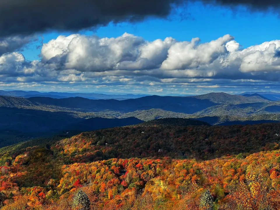 Blue Ridge peaks in autumn color under billowing clouds, seen from Beech Mountain