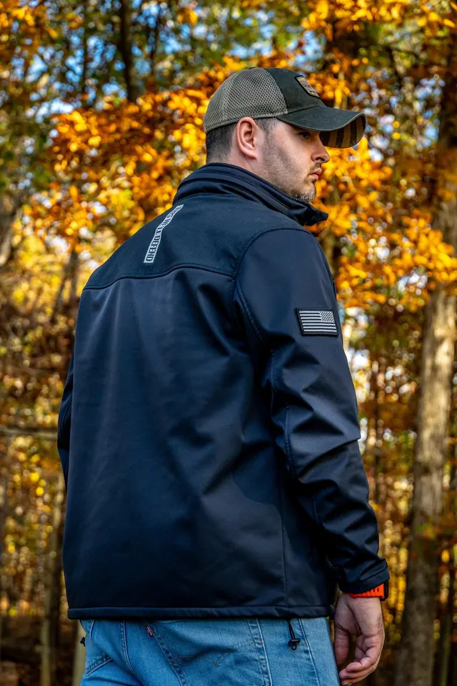 Christian in a navy jacket and cap, looking over his shoulder in autumn woods