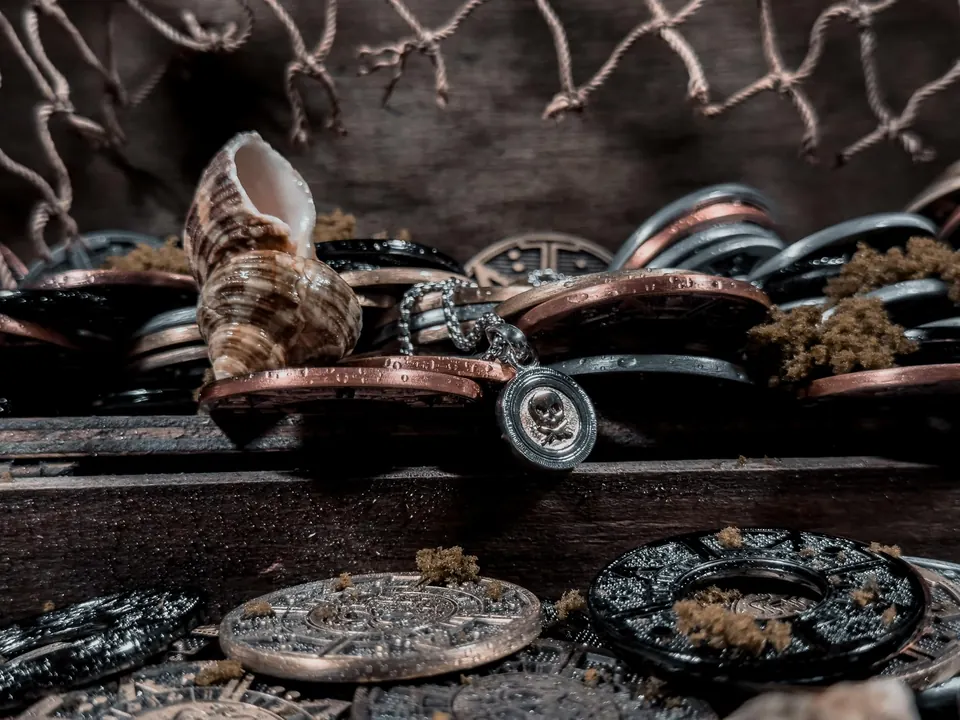 Old coins and a seashell arranged like pirate treasure