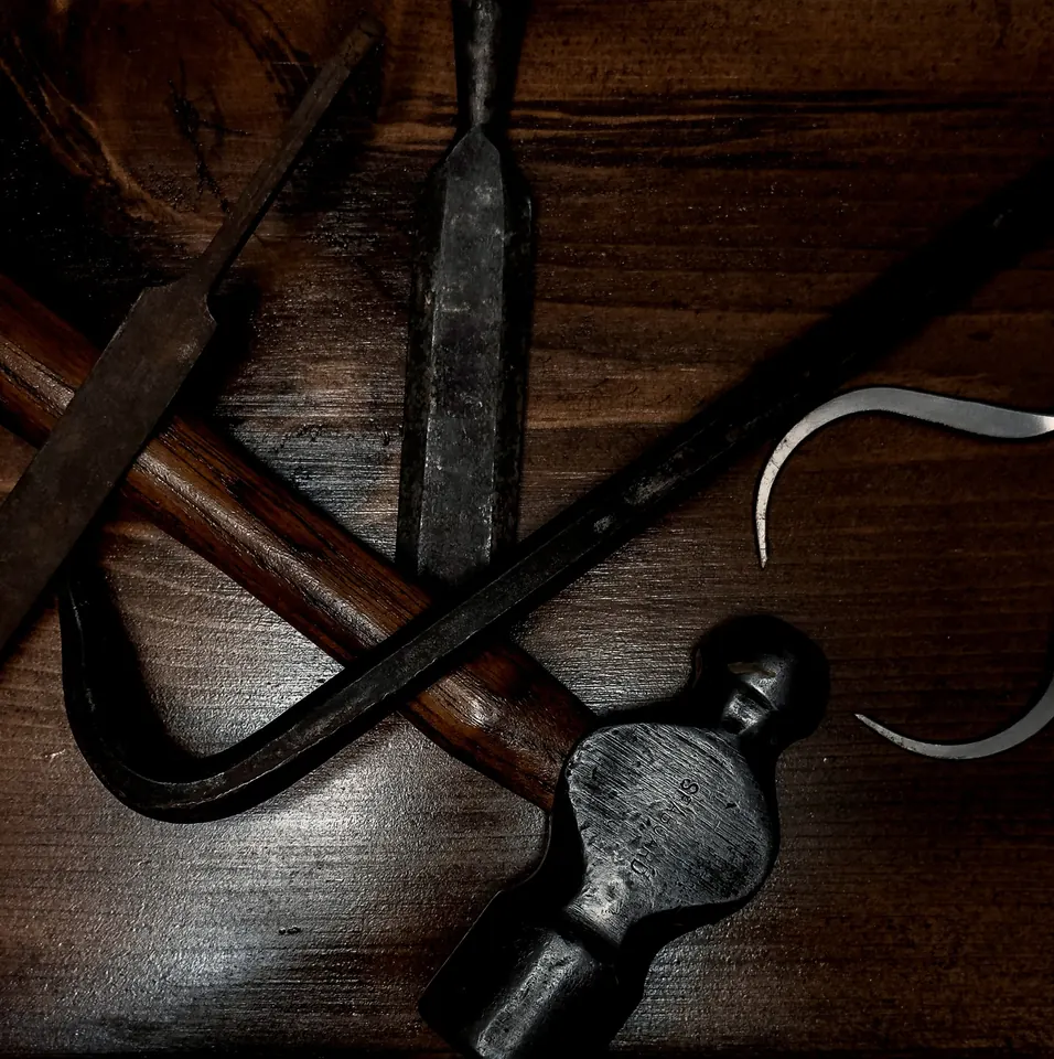 Worn woodworking tools laid out on a dark wood surface